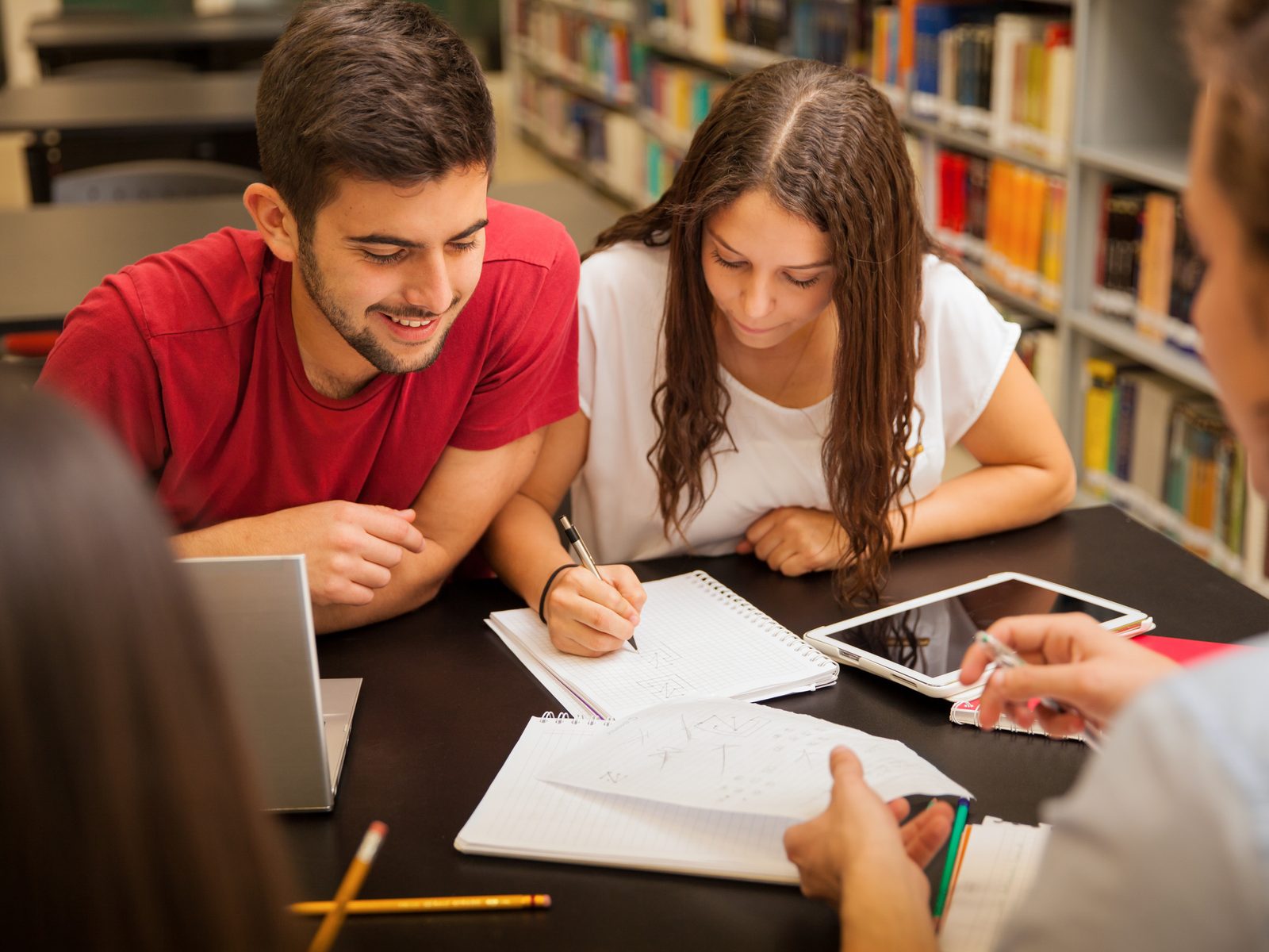 Students studying together at a library table for an associate degree in general studies